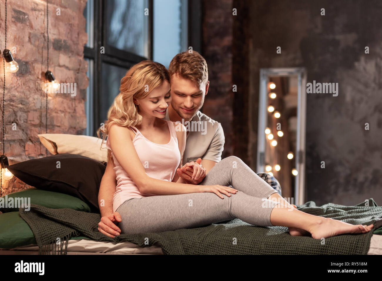 Couple wearing pyjamas passer un moment de détente dans la chambre à coucher Banque D'Images