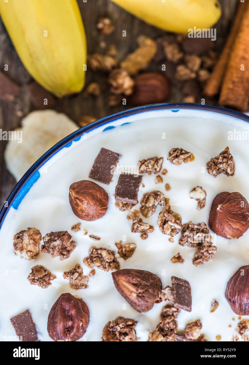 Servant de yaourt blanc avec du muesli, banane et noix Banque D'Images