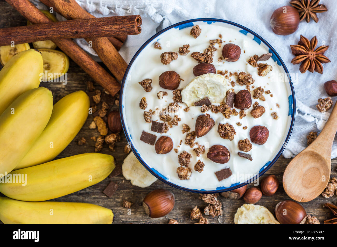 Servant de yaourt blanc avec du muesli, banane et noix Banque D'Images