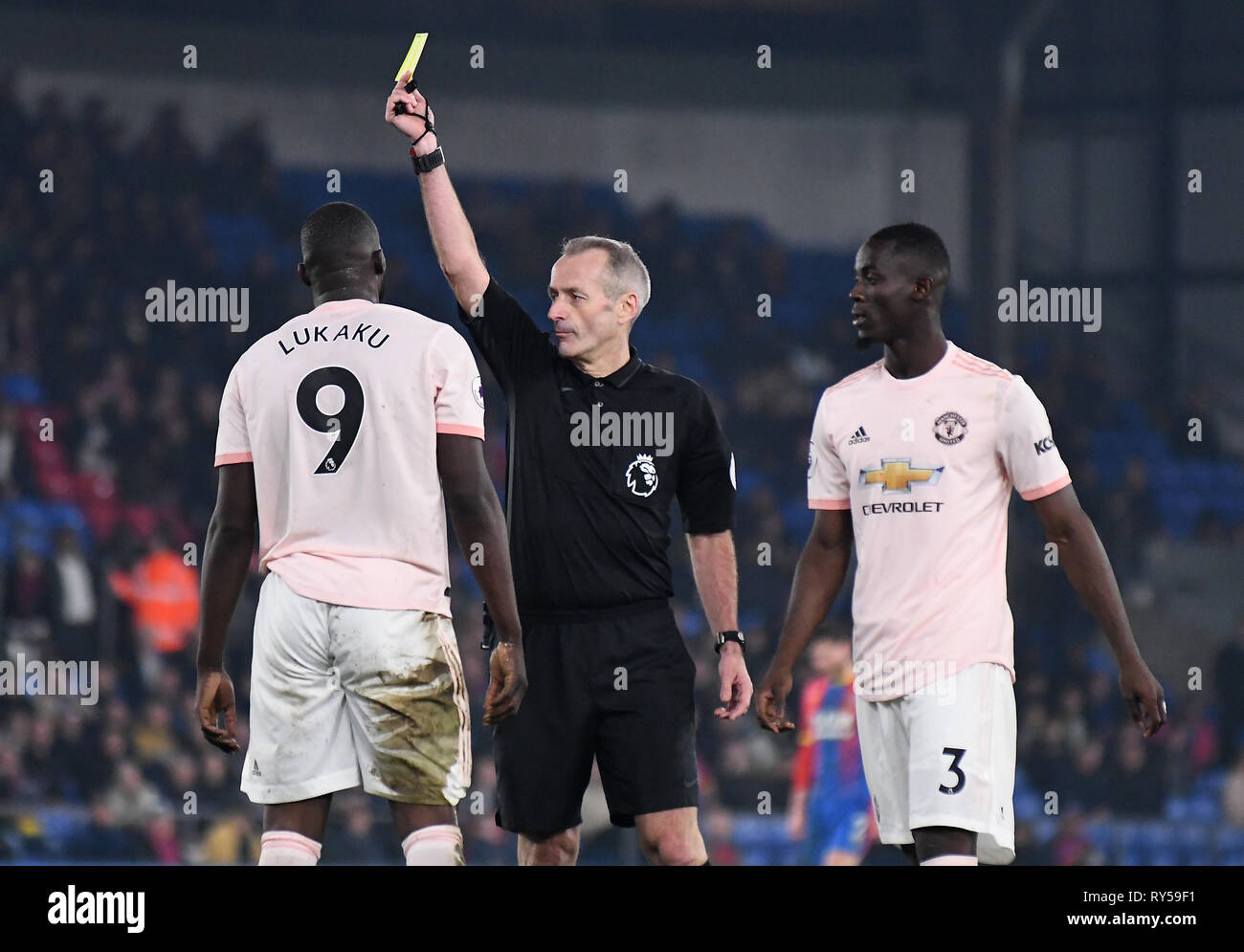 Londres, ANGLETERRE - 27 février 2019 : Anglais arbitre Martin Atkinson montre une carte jaune à Romelo Lukaku de Manchester au cours de la Premier League 2018/19 match entre Crystal Palace FC et Manchester United à Selhurst Park. Banque D'Images