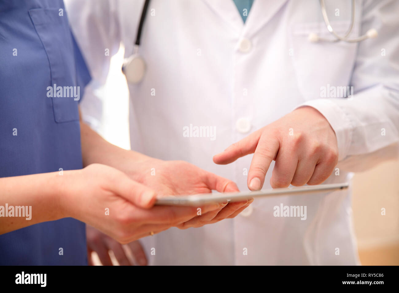 Doctor and nurse discussing patients essais a tablet computer in hospital Banque D'Images