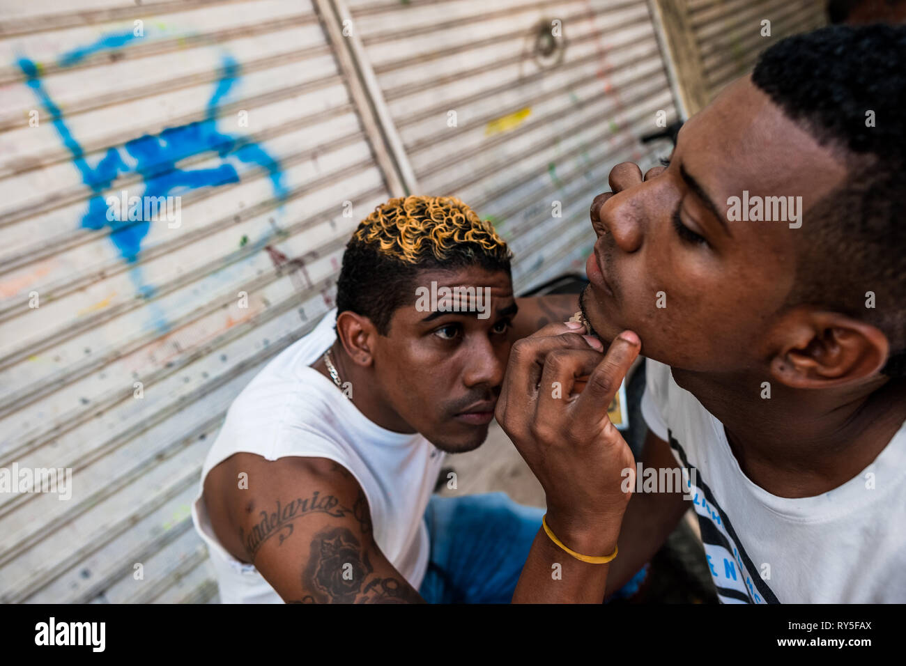 Un jeune homme un ami Colombien se rase la barbe avec une lame de rasoir dans le marché d'Bazurto, Cartgena, Colombie. Banque D'Images