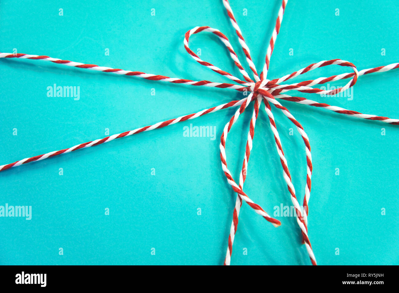 Boîte cadeau Turquoise. fond corde rouge et blanc noeud sur un fond bleu. Banque D'Images