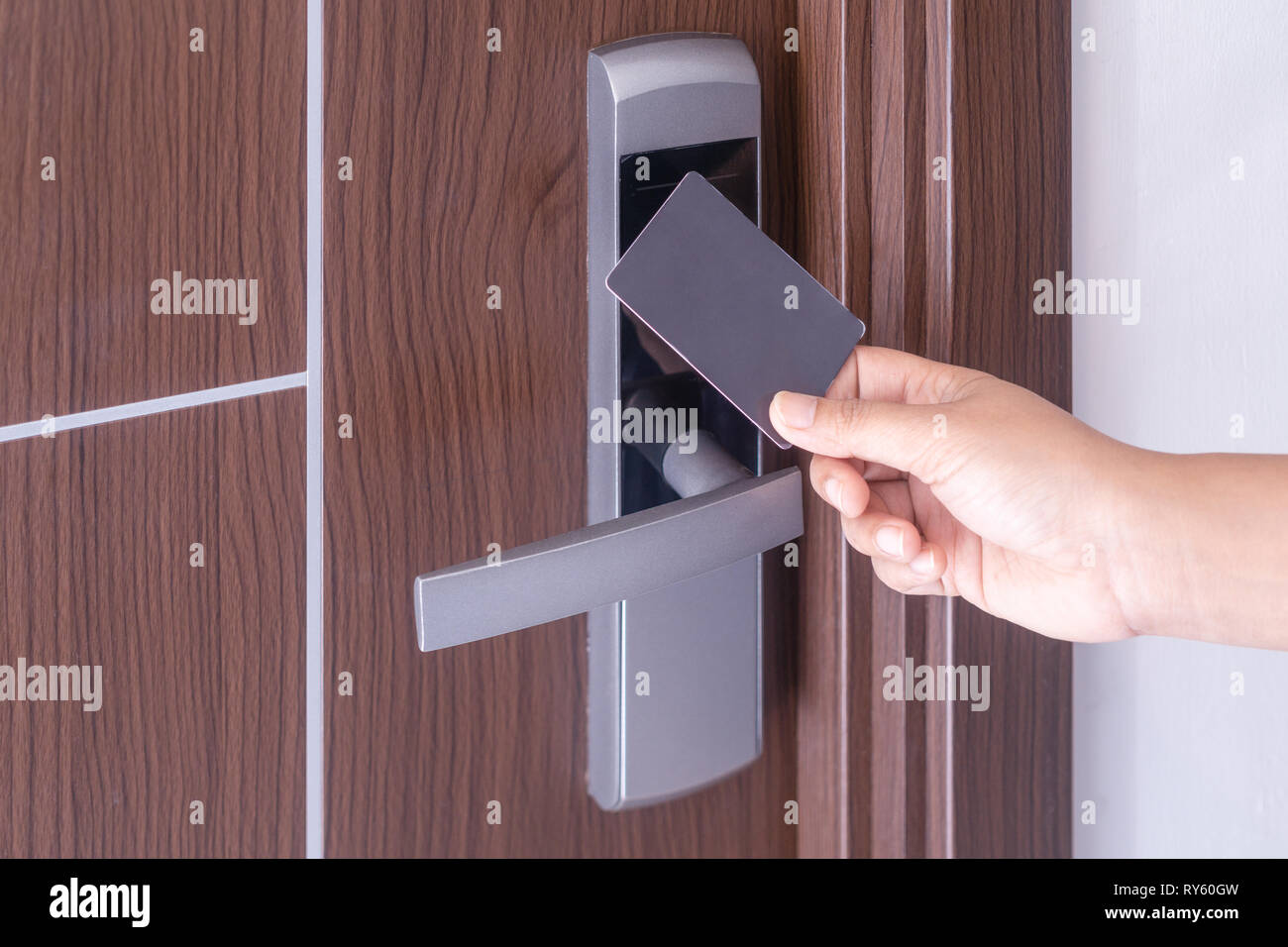 La main à l'aide d'une carte sans contact à puce électronique pour déverrouiller la porte dans l'hôtel ou maison. Banque D'Images
