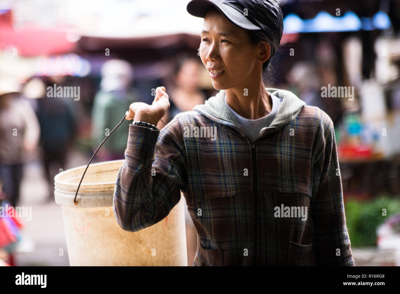 Vietnamienne portant un seau dans le marché d'Hoi An, Vietnam Banque D'Images