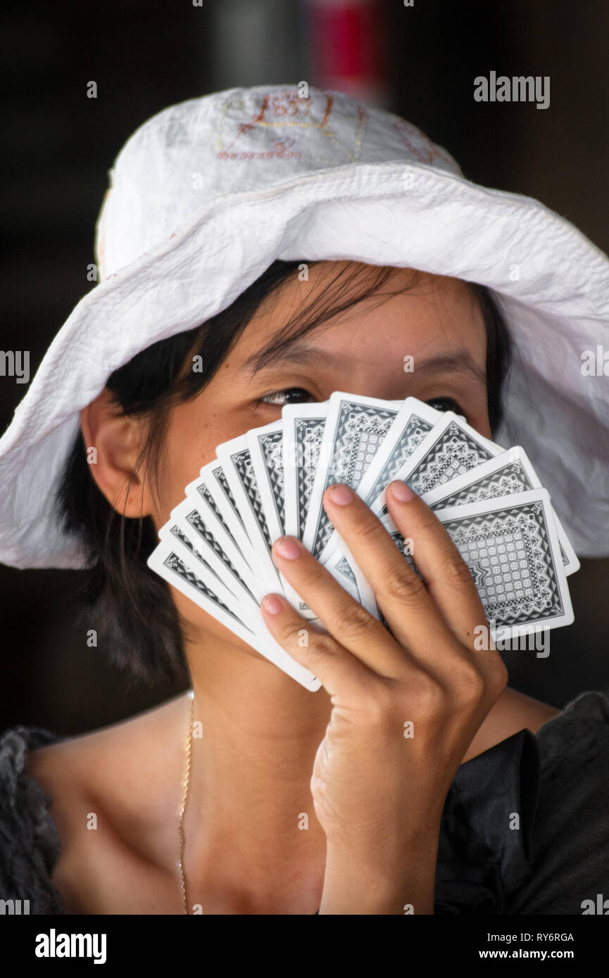 Vietnamese Woman's Face cache derrière les cartes à jouer - Hoi An, Vietnam Banque D'Images