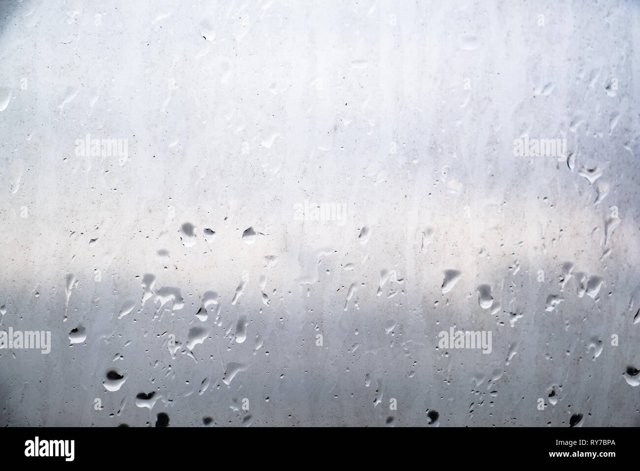 Сoncept de pollution de l'environnement dans la ville industrielle. Gouttes de pluie sur la vitre sale, vue rapprochée. Banque D'Images
