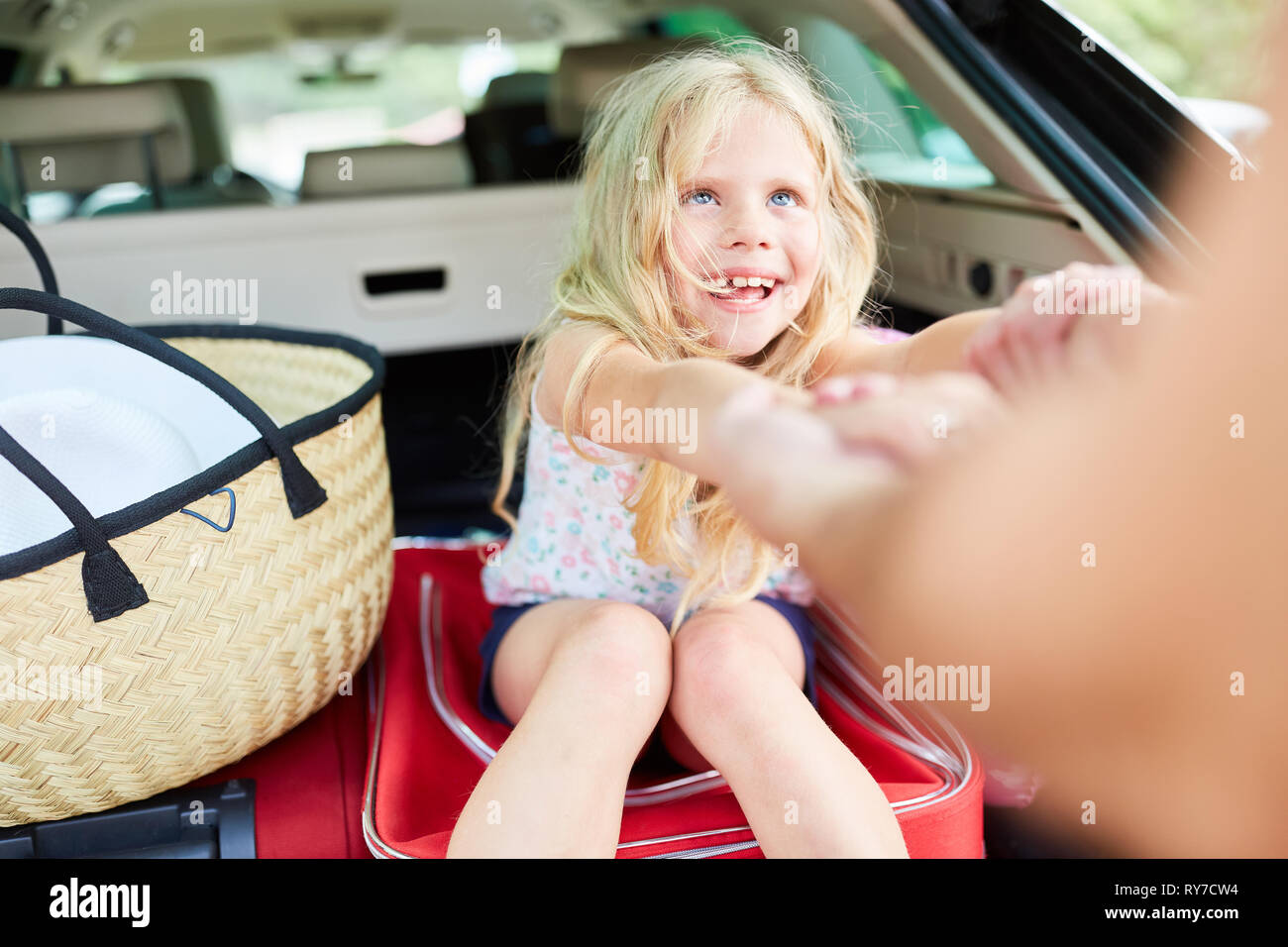 Happy girl est de jouer sur l'assurance dans la voiture avant de partir en vacances Banque D'Images