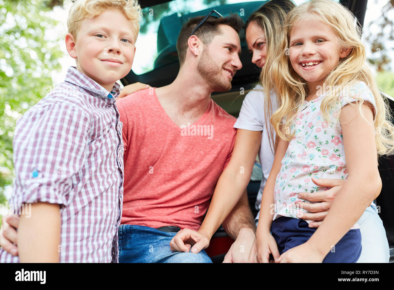 Famille et enfants harmonieux ensemble dans la voiture avant les vacances d'été Banque D'Images
