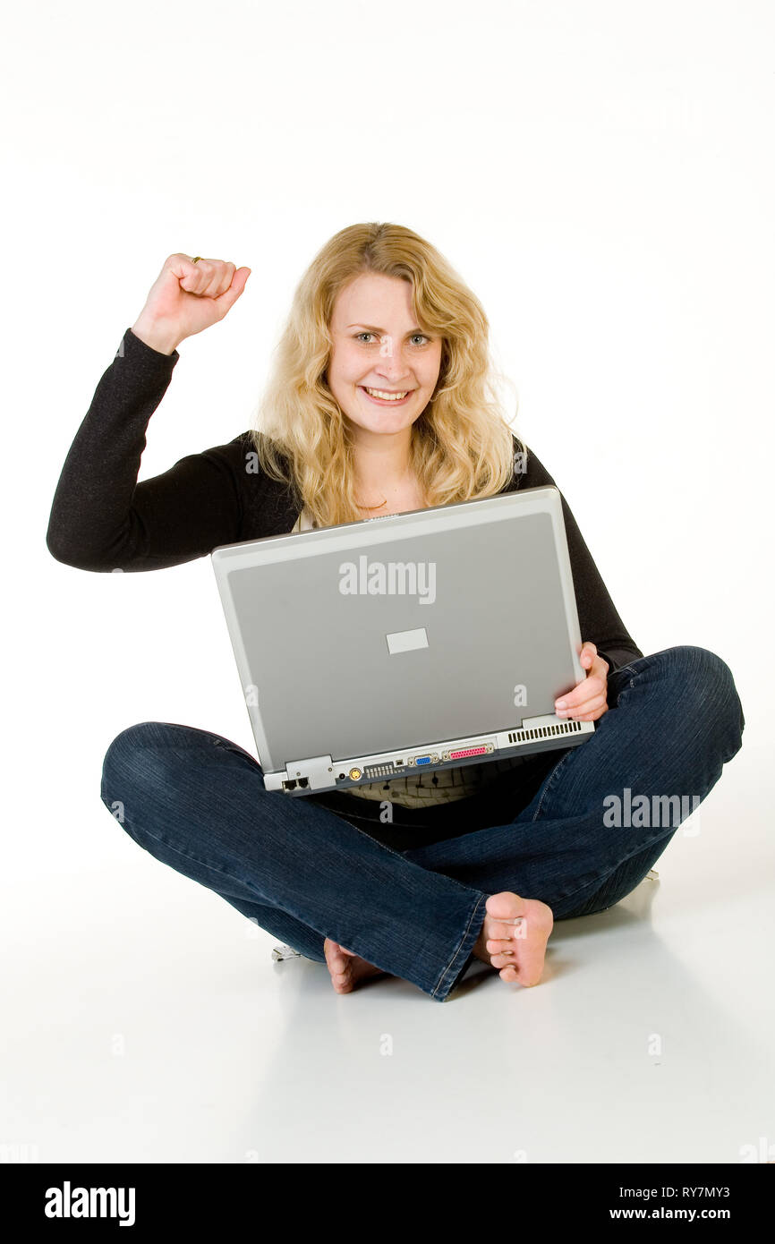 Une jeune femme se trouve en face de son ordinateur portable. Isolé à partir d'un fond blanc. Banque D'Images