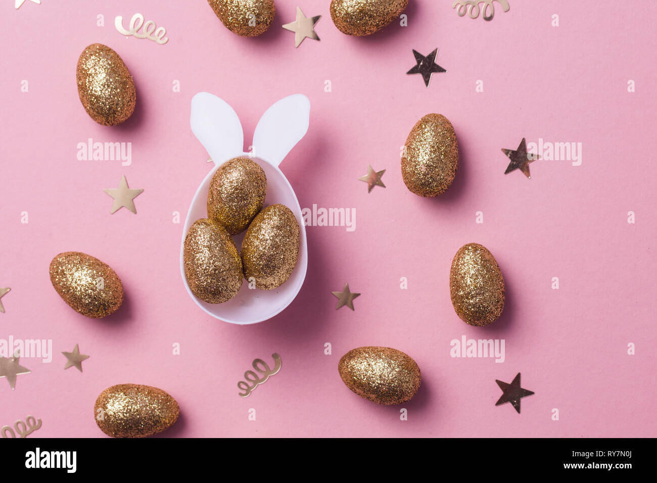 Gold glitter oeufs dans un lapin de pâques blanc forme des oeufs avec les oreilles Banque D'Images