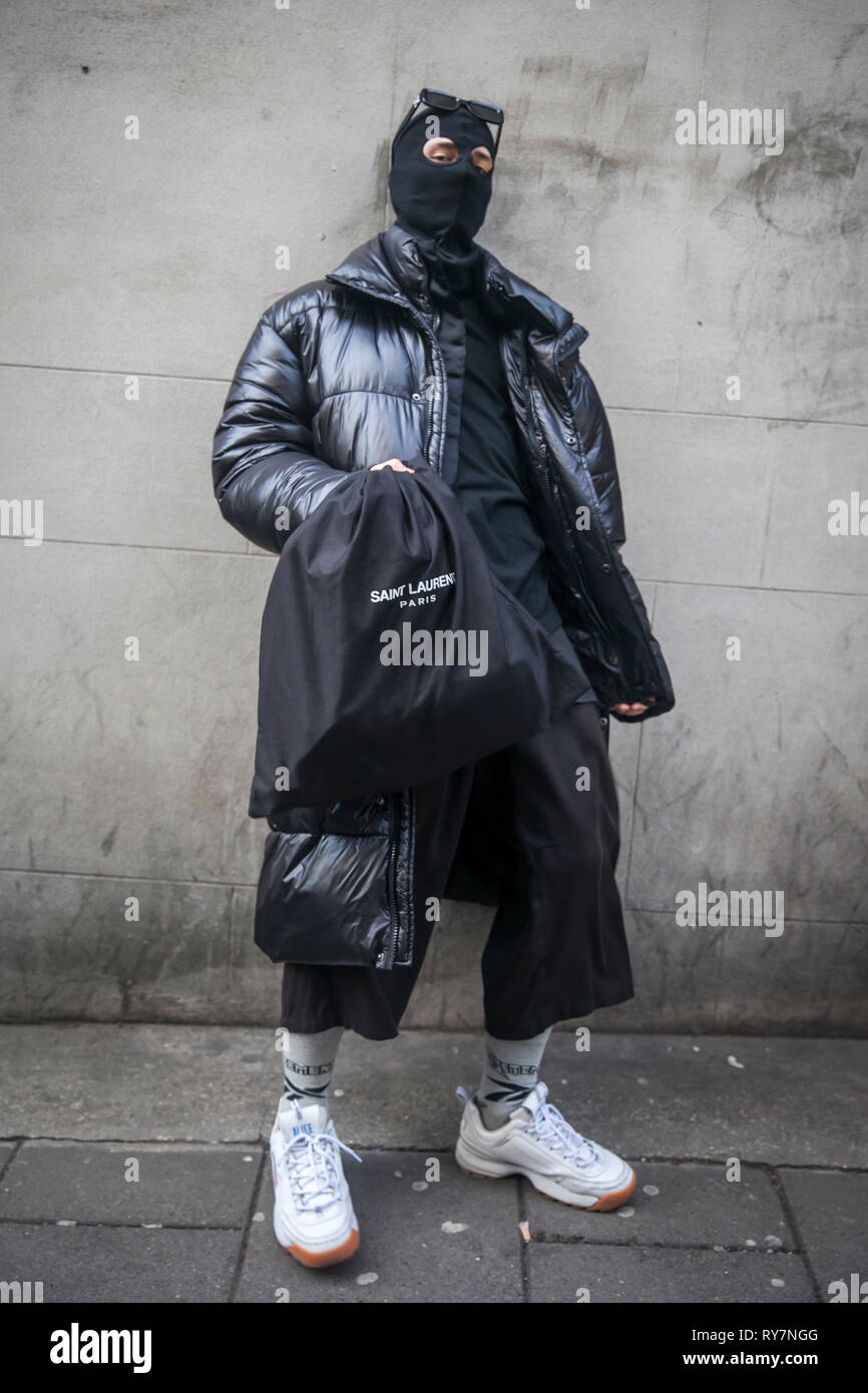 LONDON 17 fevrier 2019 la Semaine de la mode de Londres. L homme blond clair porte sac ceinture en PVC noir veste vers le bas et un pantalon gris blanc sneakers