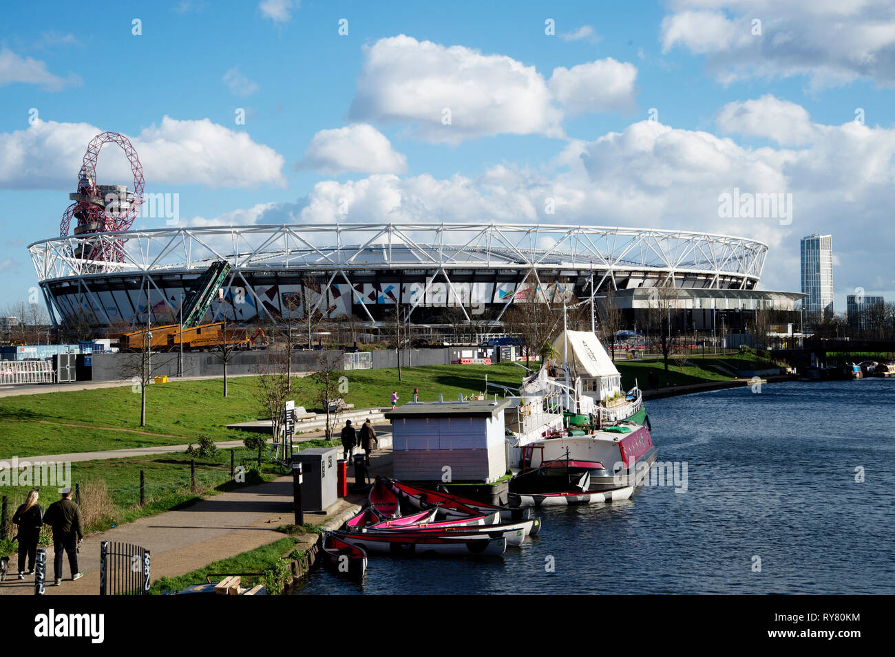 Londres. Hackney. Lea canal de navigation avec des kayaks, péniche bar et une vue sur le stade olympique. Banque D'Images