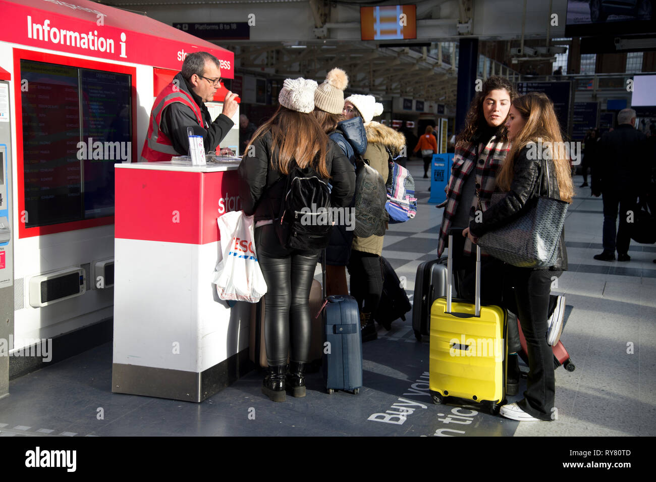 La gare de Liverpool Street. Londres. Un groupe de jeunes femmes touristes demandent de l'information. Banque D'Images