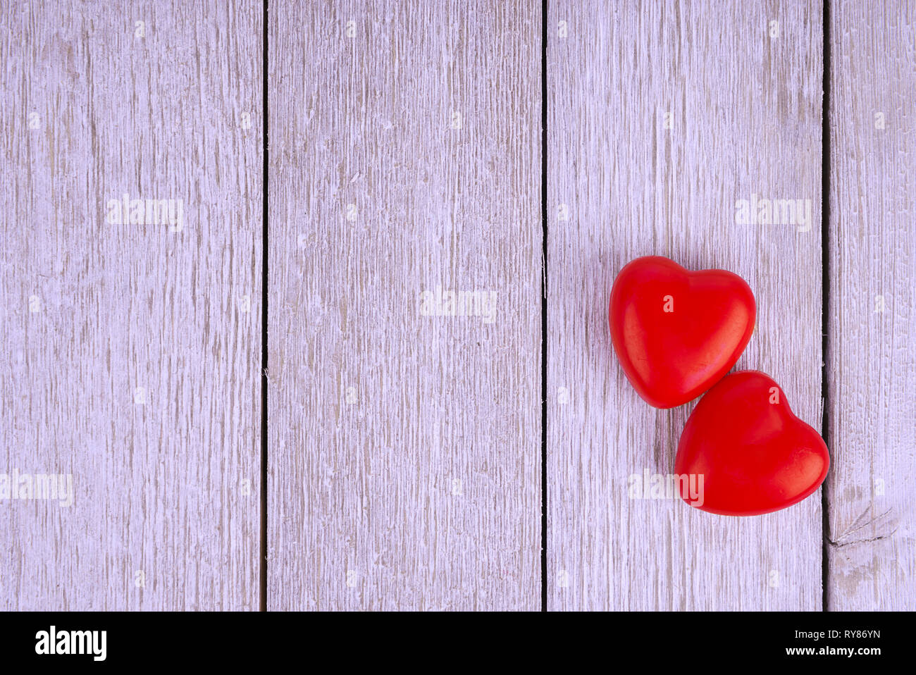 Deux cœurs sur une planche en bois blanc, juste au-dessus. Copie de l'espace pour votre texte. Banque D'Images