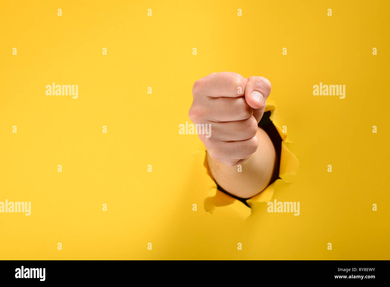 Fist a brisé le mur de papier jaune Banque D'Images