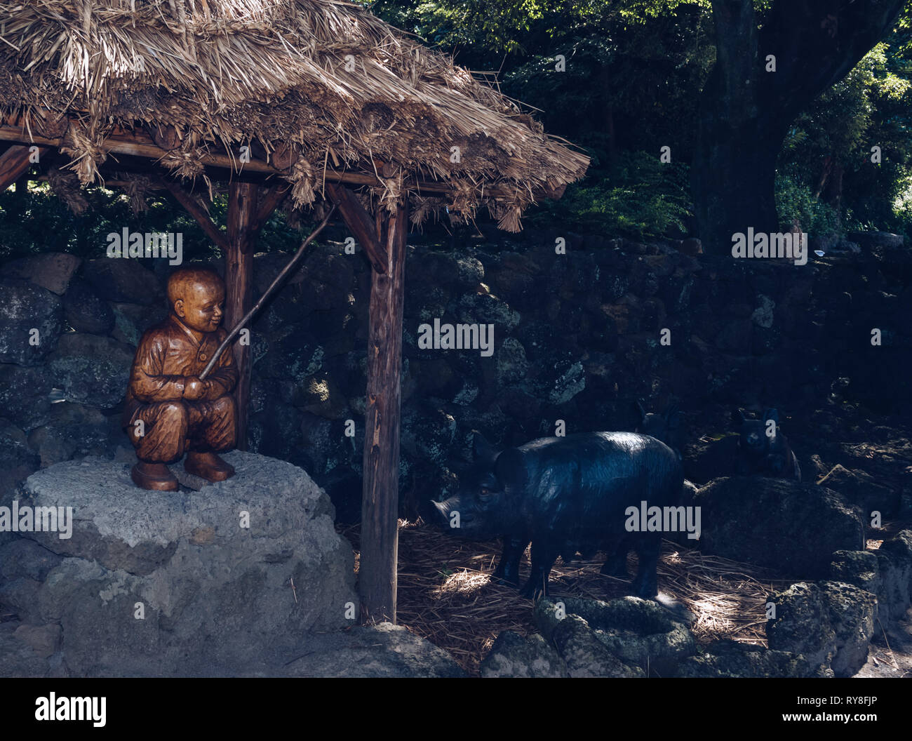 L'île de Jeju, Corée du Sud, 09 septembre 2015 : sculpture en bois de garçon swineherd cochon noir et célèbre sur l'île de Jeju Banque D'Images
