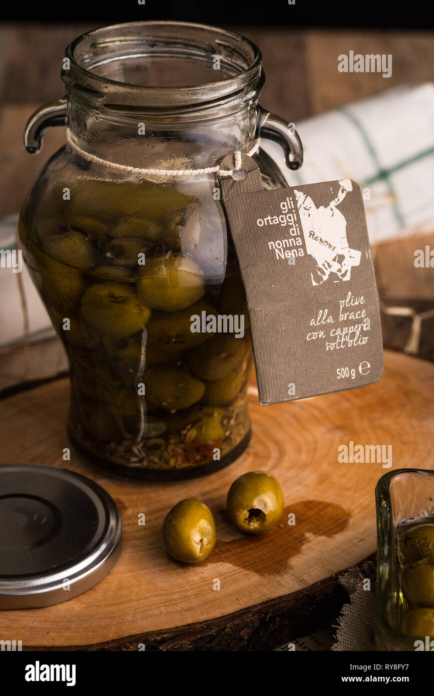 Verser la bouteille de l'huile d'olive vierge dans un bol close up Banque D'Images