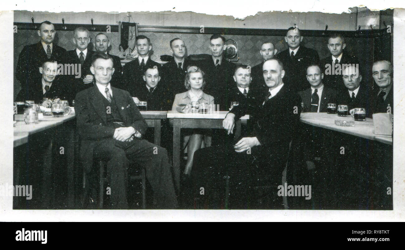 L'Allemagne. 1933s, le Troisième Reich, une Allemande boit de la bière d'un bakala entouré par 17 hommes. Banque D'Images