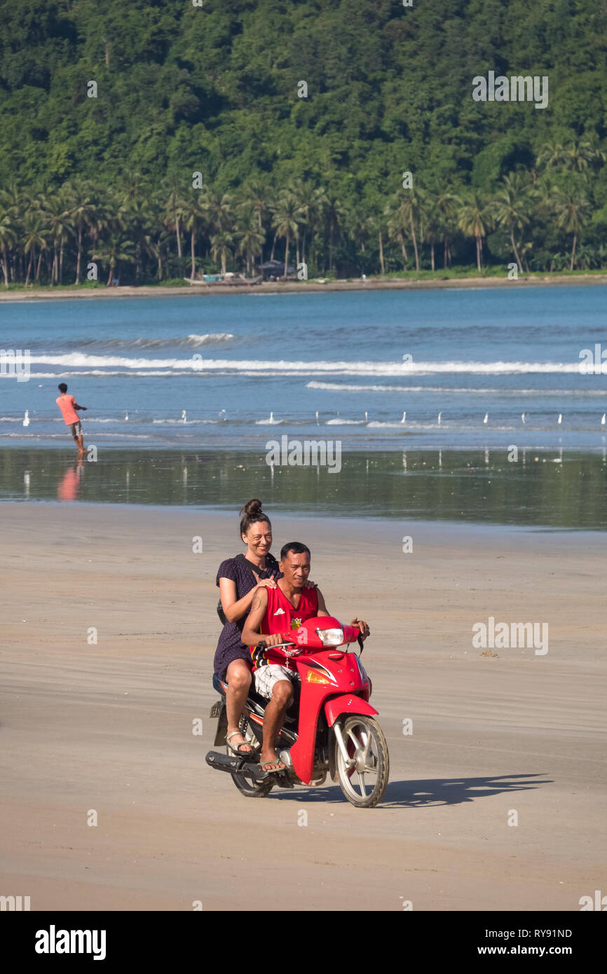 L'Eurpoean équitation à l'arrière de moto par la mer - San Vicente de la plage Long, Palawan - Philippines Banque D'Images