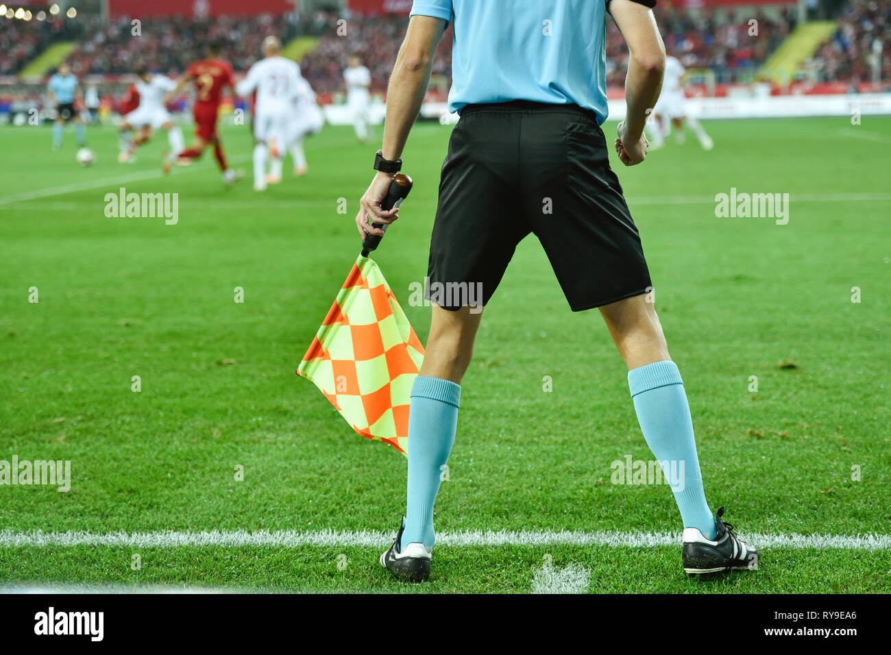 Arbitre de football de l'Assistant avec le drapeau sur la ligne de touche. Banque D'Images