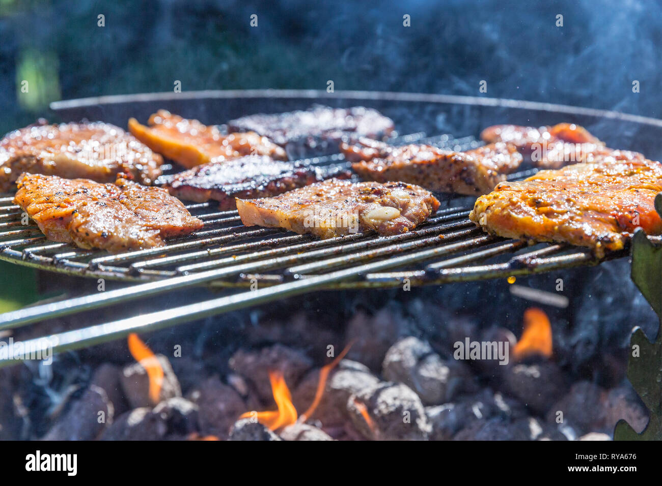 Wuerstchen Bauchfleisch und auf dem Grill, Unter dem Grill lodern die  Flammen bei THEMENBILD Grillen, 06.05.2018 Foto : Mario Hommes Photo Stock  - Alamy