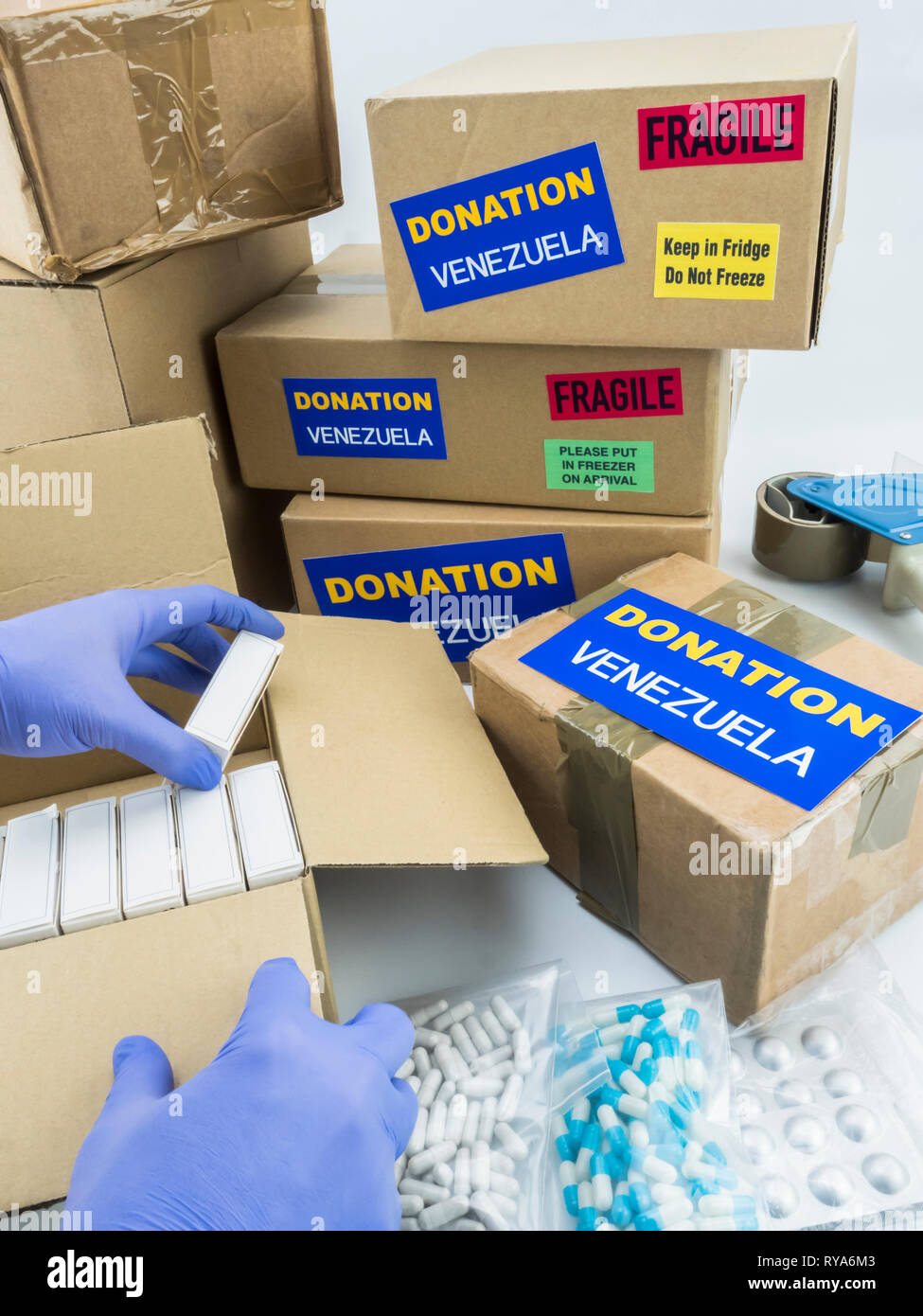 L'aide humanitaire, de l'infirmière en plaçant des boîtes avec des médicaments pour envoyer le Venezuela, conceptual image Banque D'Images