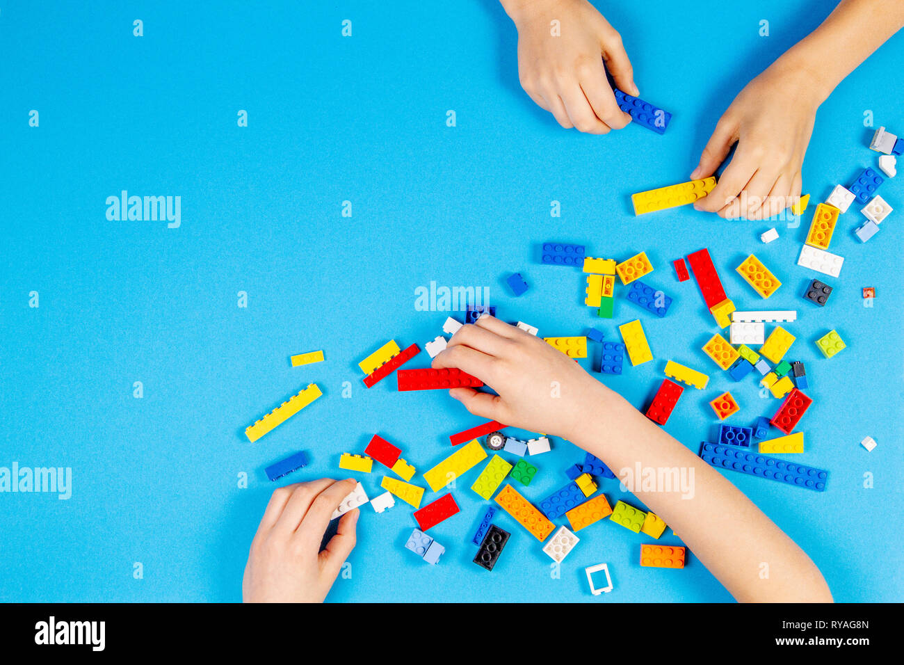 Les mains des enfants jouer avec des blocs Lego colorés sur la table Banque D'Images