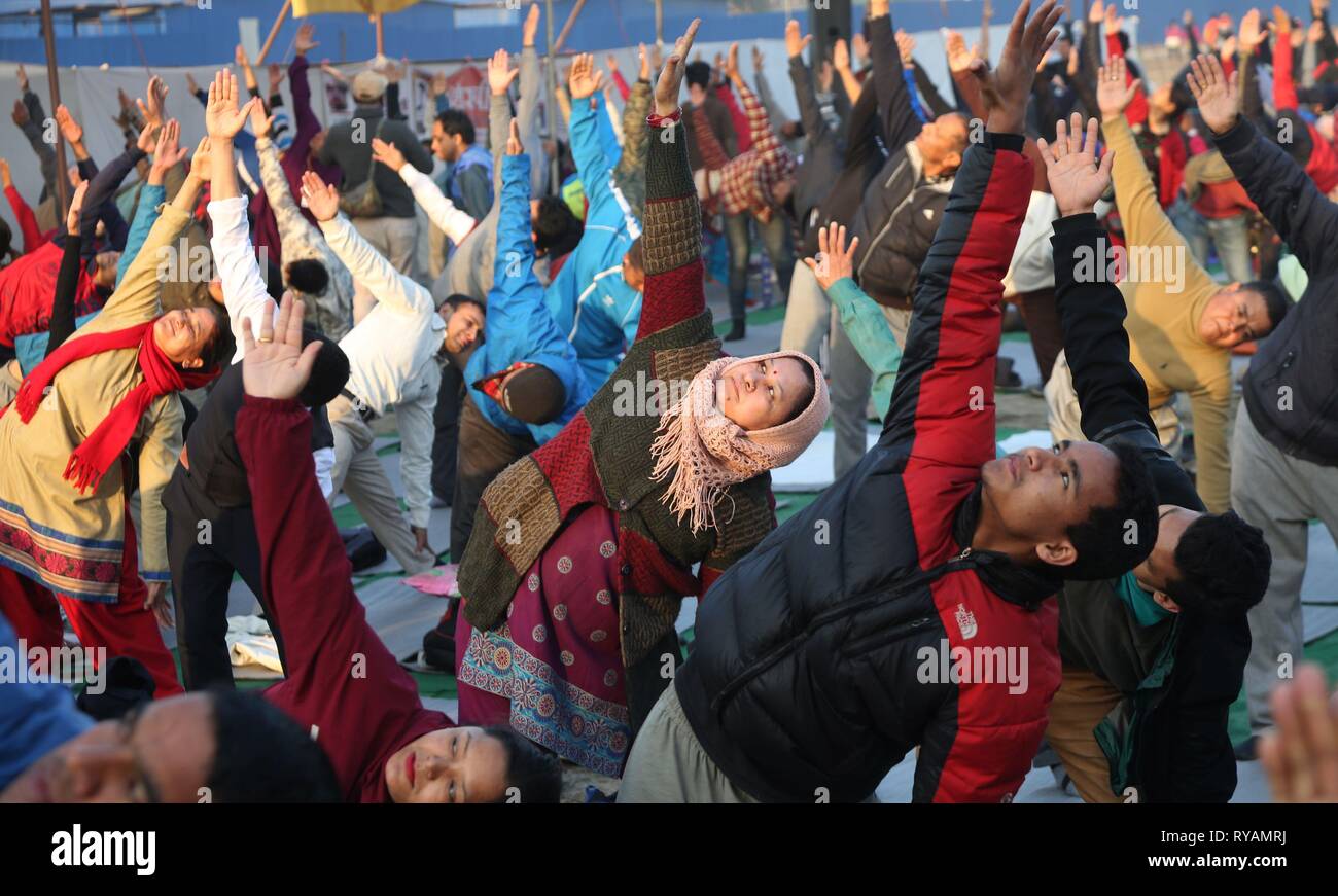 Katmandou, Népal. Mar 13, 2019. La pratique du peuple népalais étapes yoga tôt le matin à Tundikhel à Katmandou, Népal, 13 mars 2019. Le Yoga est de plus en plus populaires au Népal comme les gens le considèrent comme non seulement un exercice physique, mais aussi comme une discipline spirituelle et mentale. Credit : Sunil Sharma/Xinhua/Alamy Live News Banque D'Images