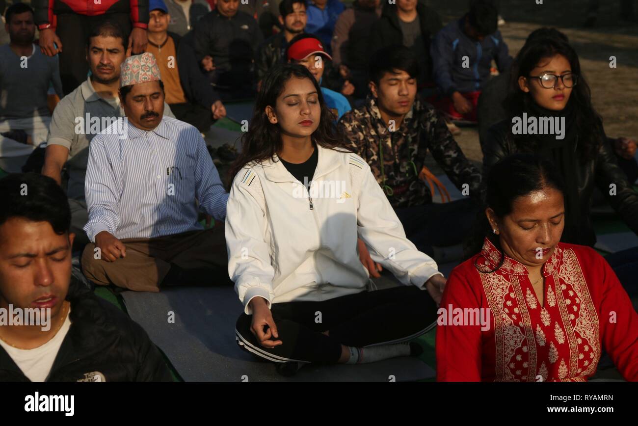Katmandou, Népal. Mar 13, 2019. Népalais pratiquer la méditation tôt le matin à Tundikhel à Katmandou, Népal, 13 mars 2019. Le Yoga est de plus en plus populaires au Népal comme les gens le considèrent comme non seulement un exercice physique, mais aussi comme une discipline spirituelle et mentale. Credit : Sunil Sharma/Xinhua/Alamy Live News Banque D'Images
