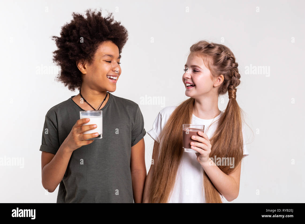 Rire agréable enfants vêtus de t-shirts et comité permanent en étroite collaboration Banque D'Images