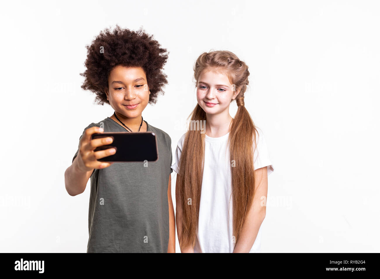 Pretty young kids ensemble selfies sur smartphone Banque D'Images