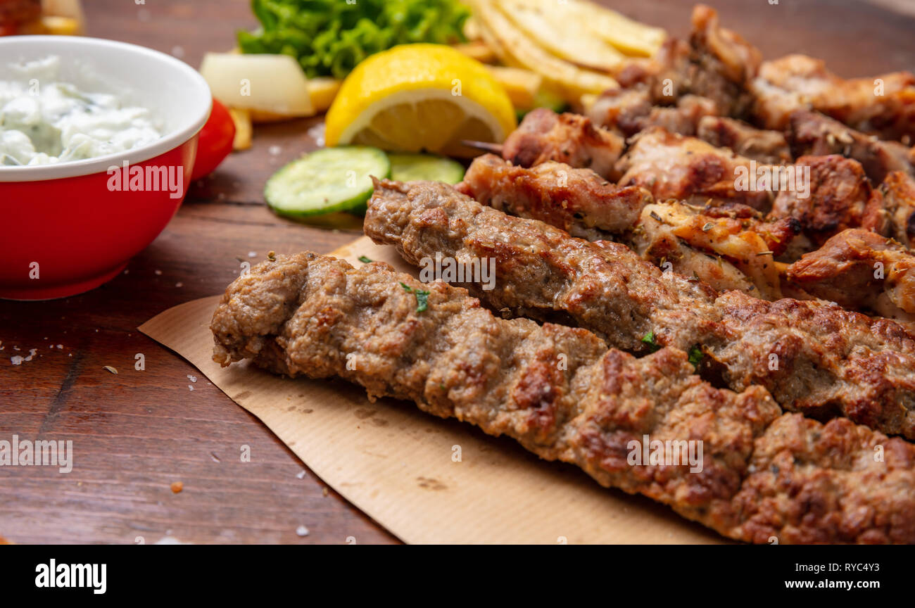 Kebab, turc, grec traditionnel sur table en bois de la viande, les pommes de terre et sauce tzatziki Banque D'Images