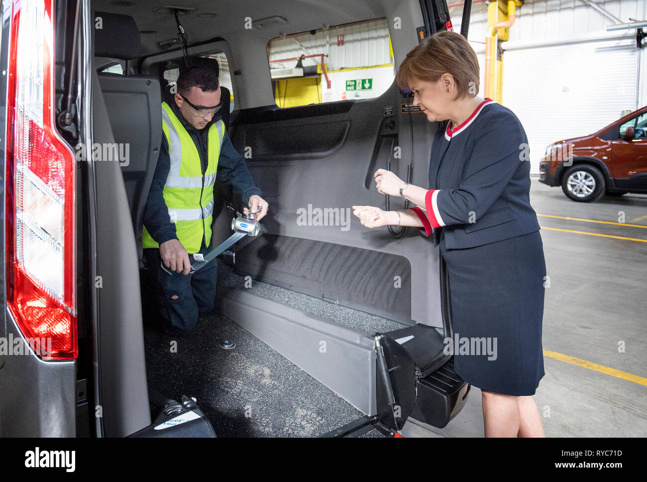 Premier ministre Nicola Sturgeon avec chef d'équipe Chris Beard (à gauche) au cours d'une visite à véhicules alliés Ltd à Glasgow où les voitures sont transformées et modifiées pour les rendre accessibles en fauteuil roulant. Banque D'Images