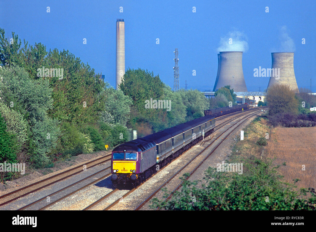 Un certain nombre de locomotives diesel de la classe 57 57601 se dirige vers l'ouest avec un premier grand service de l'ouest pendant qu'en arrière-plan un MGR chargé avec du charbon importé attend d'entrer dans la centrale. Milton près de Didcot. 23 avril 2002. Banque D'Images