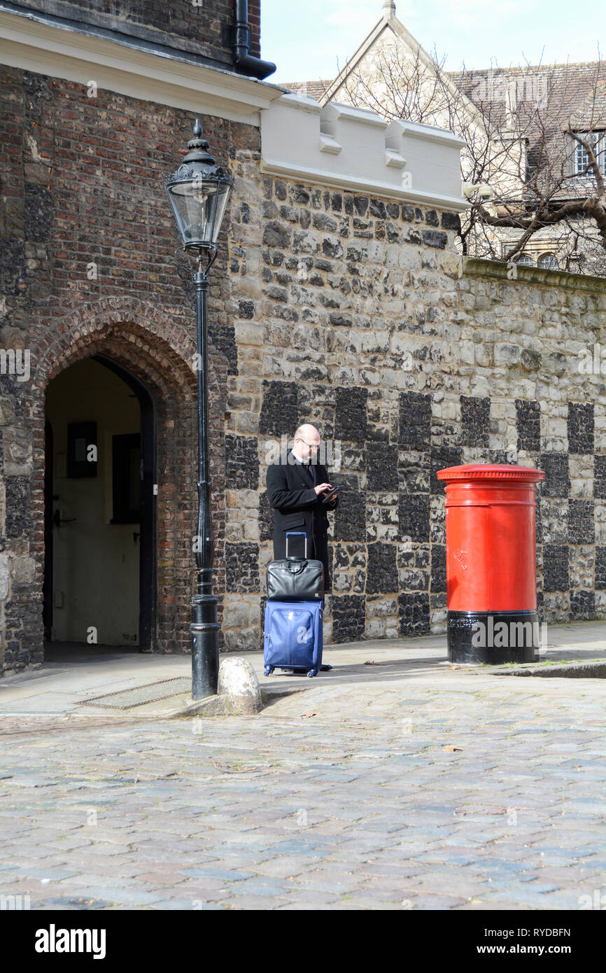 Un membre du clergé textos en Charterhouse Square, London, UK Banque D'Images
