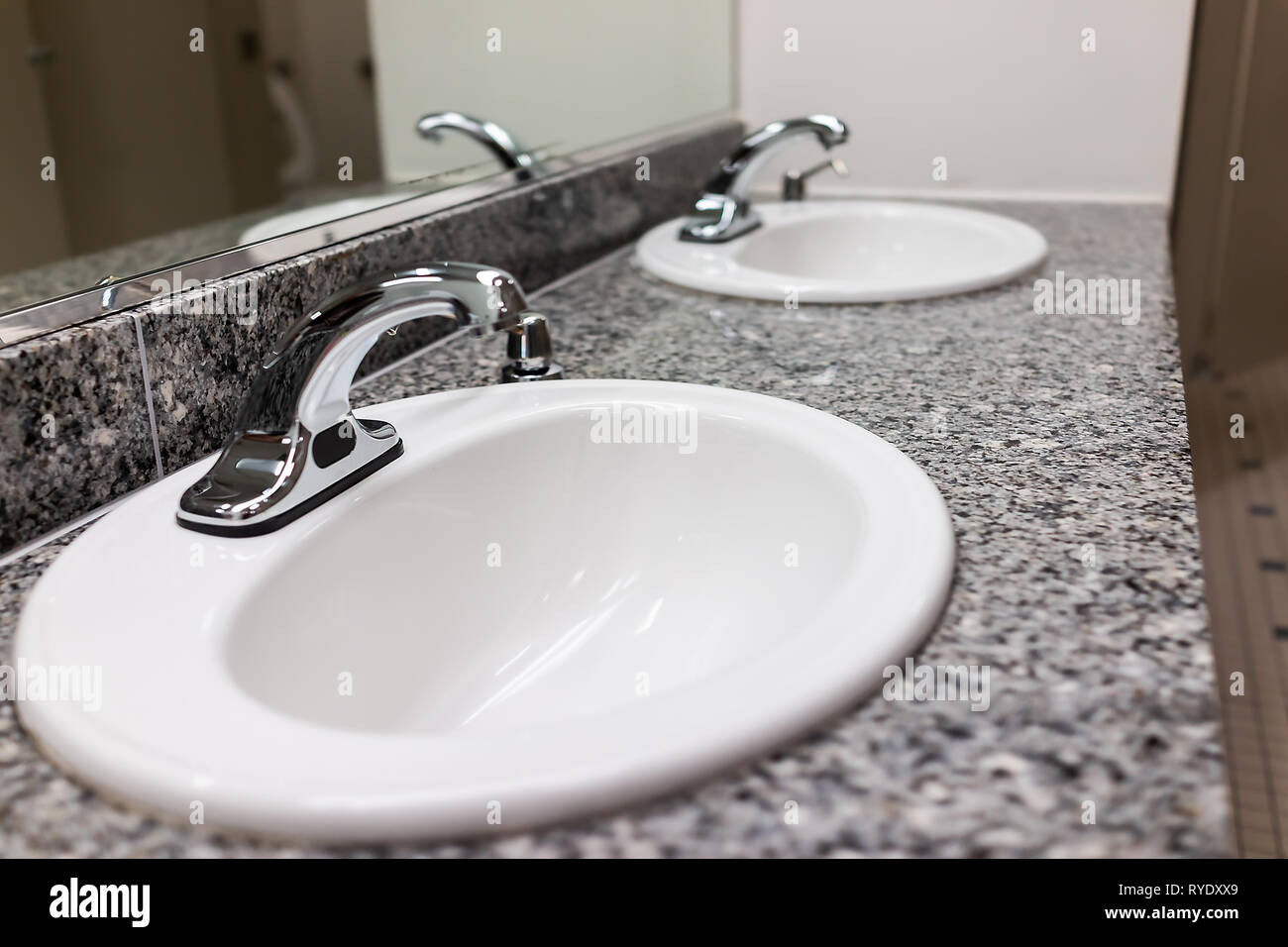 Rangée de puits modernes dans les toilettes wc avec distributeur de savon et nettoyer l'arrière-plan blanc intérieur minimaliste avec robinet métal libre et le granit Banque D'Images