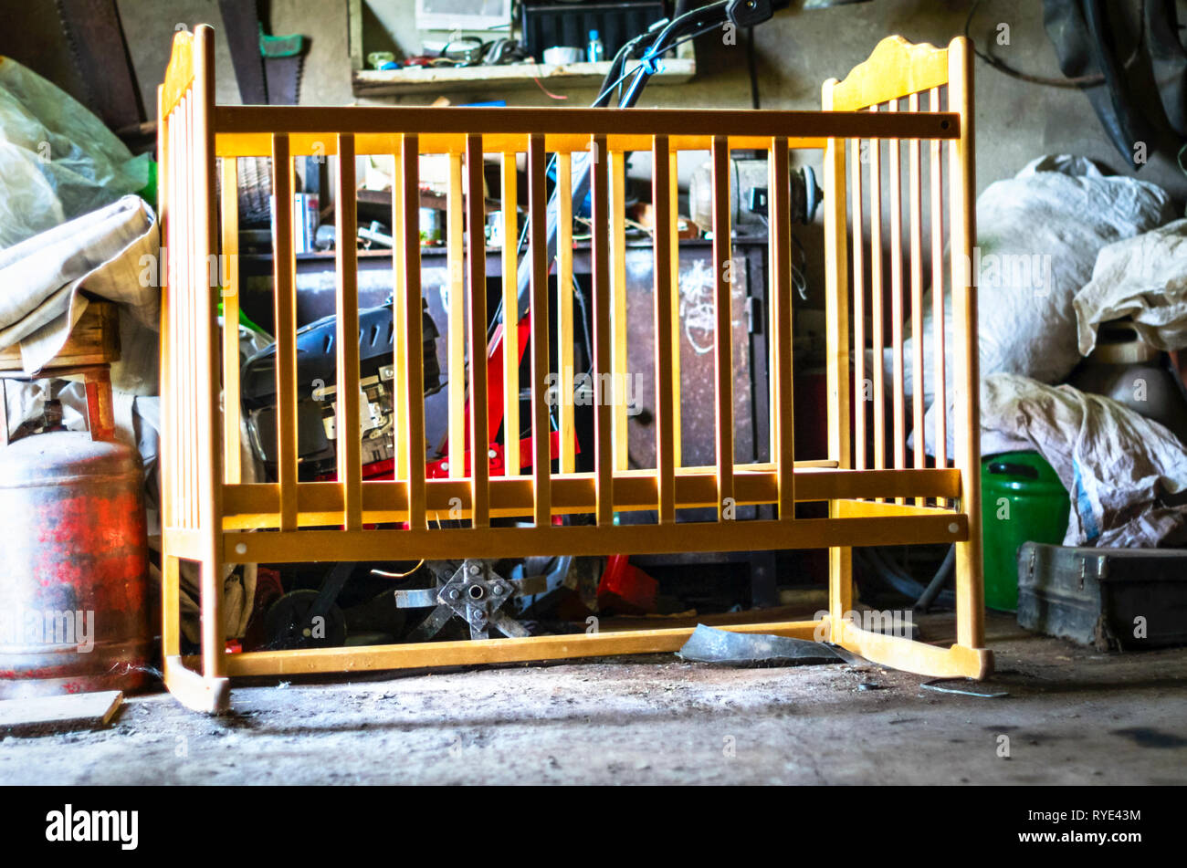 Ancienne en bois Lit bébé, berceau, lit bébé Lit dans un hangar de stockage, garage. En grandissant, la vie Concept Banque D'Images