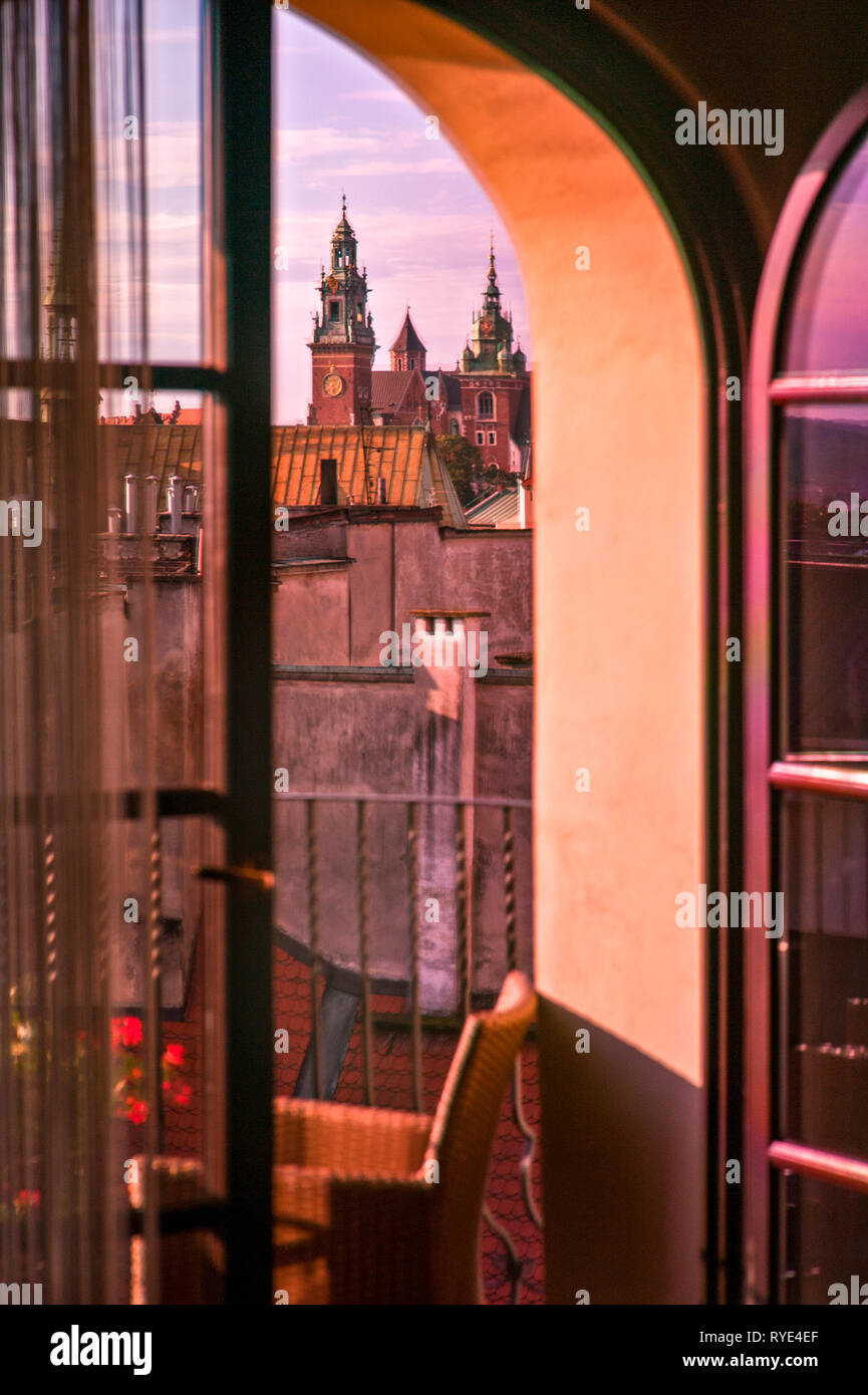 Représentant le paysage des toits de Cracovie, Pologne et une église au crépuscule à travers et fenêtre ouverte en été Banque D'Images