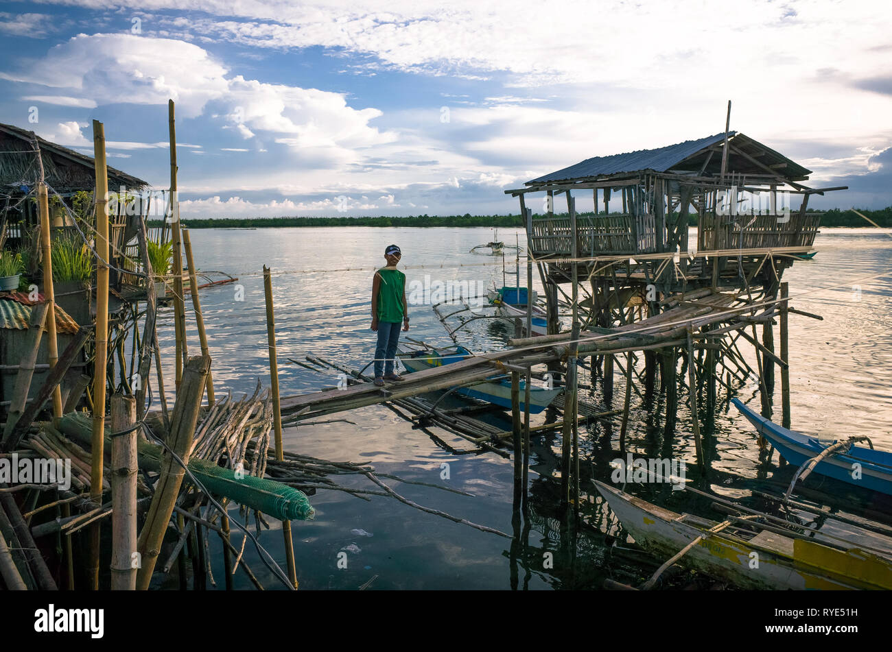 Garçon philippin avec des maisons de Village de bambou flottant - Palompon, Leyte - Philippines Banque D'Images