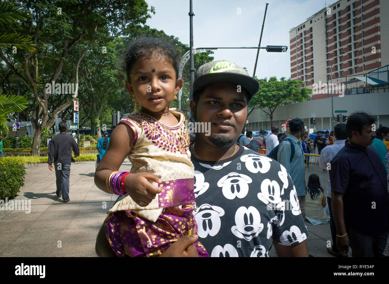 Père indien holding young smiling daughter au festival Thaipusam - Singapour Banque D'Images