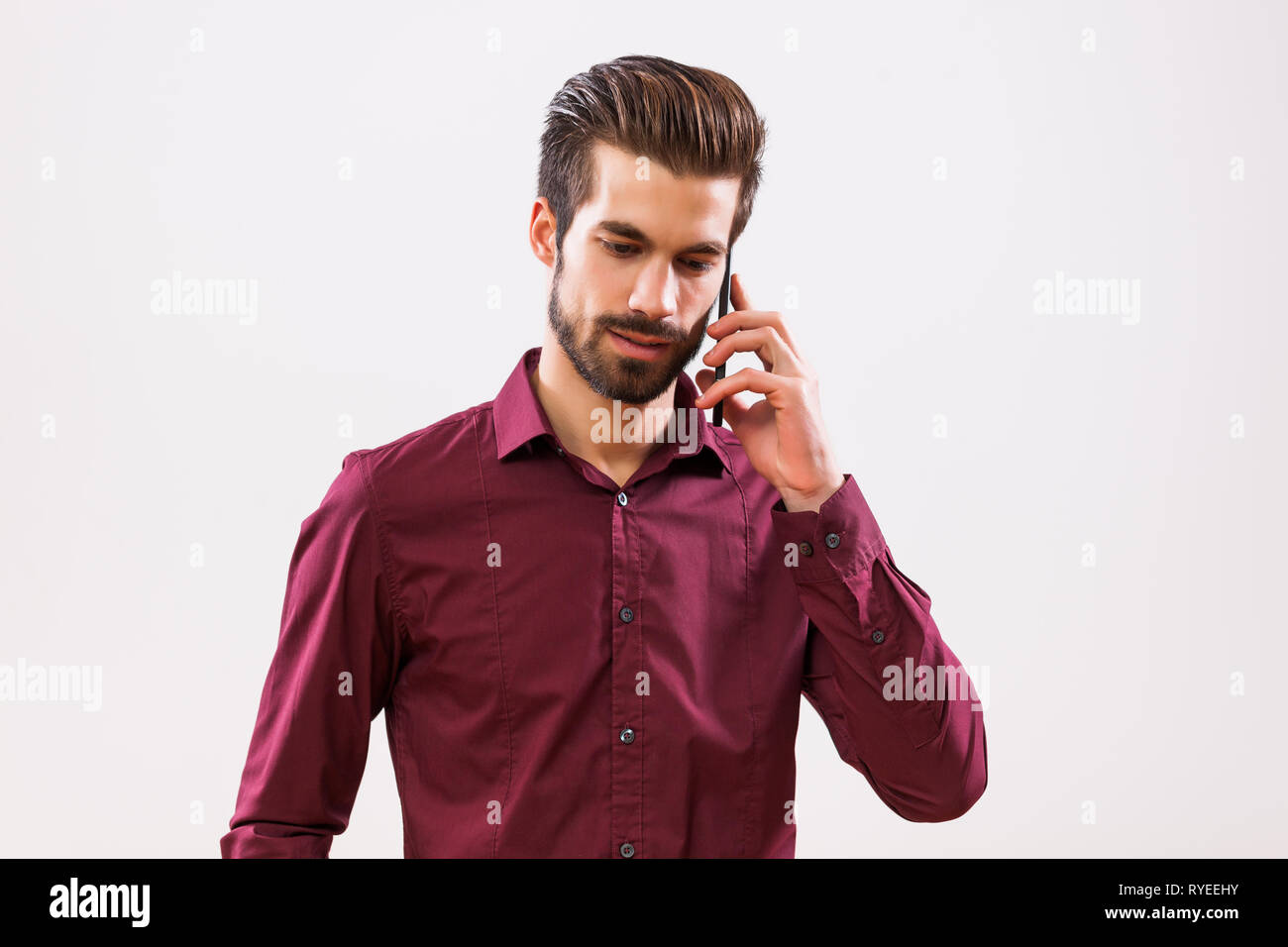 Studio shot portrait of young businessman qui parle sur le téléphone. Banque D'Images
