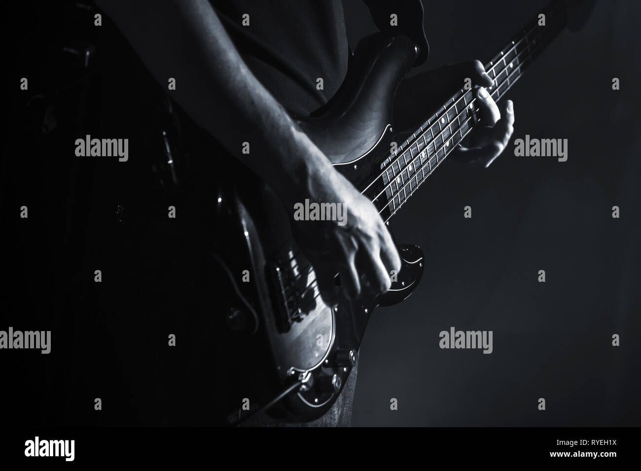 Guitare basse électrique player mains, musique en thème, close-up photo en noir et blanc Banque D'Images