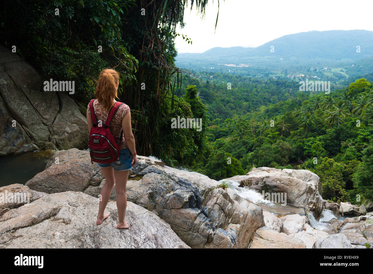 Fille debout sur une falaise de cascades de Namuang, observant la nature de l'île de Samui, Thaïlande Banque D'Images