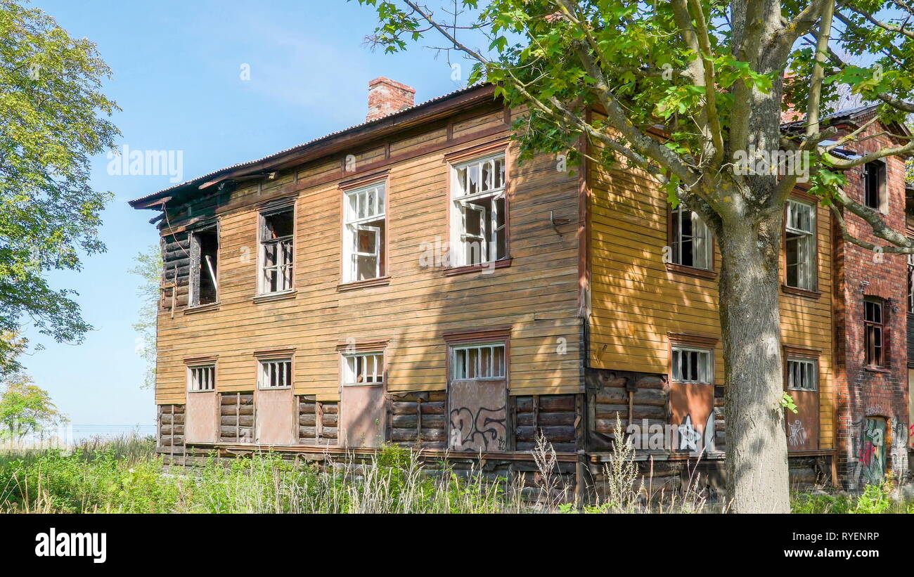 Une vieille maison abandonnée en ruine dans la rue avec les fenêtres cassées et les arbres à l'extérieur Banque D'Images