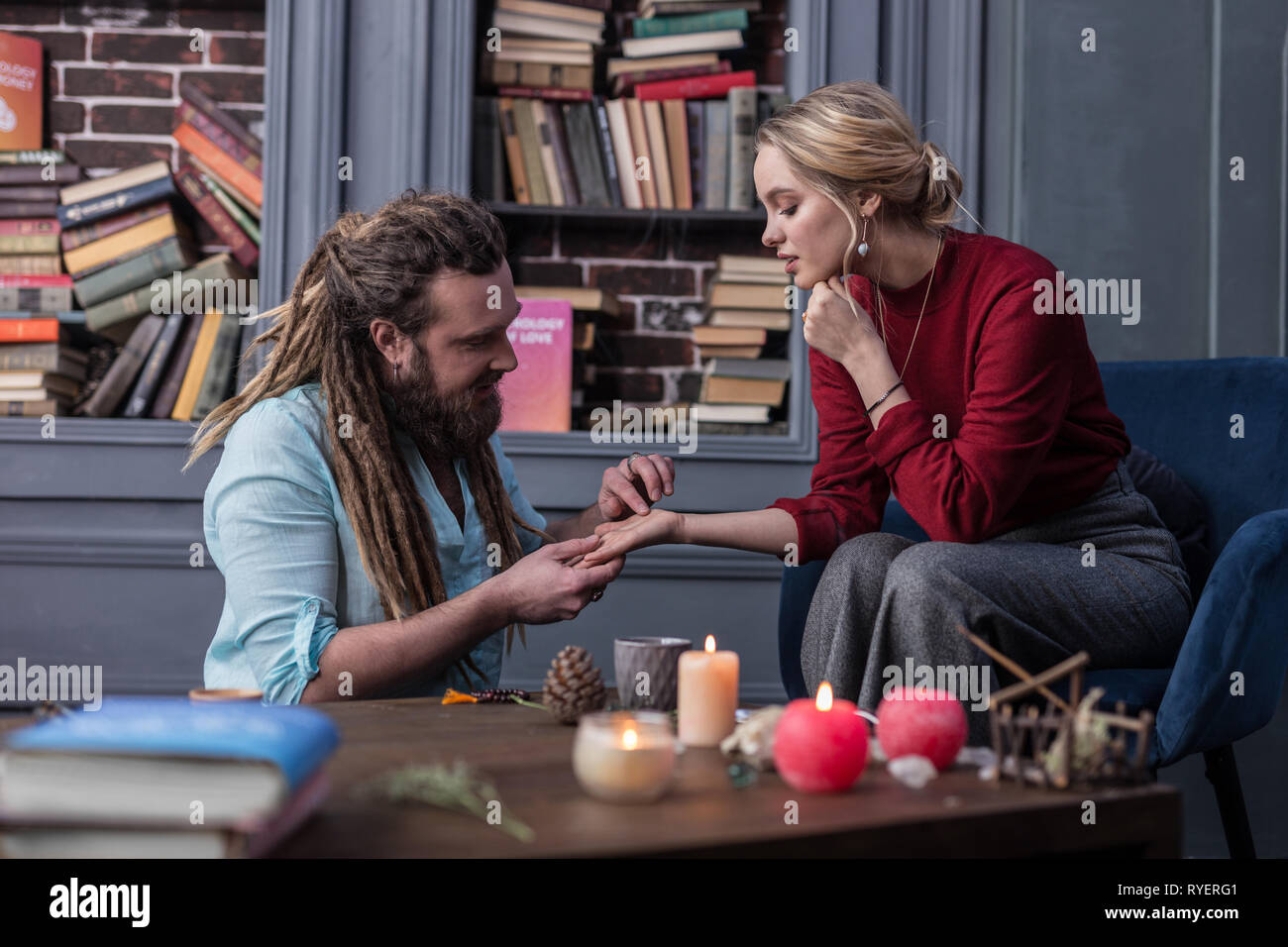 Beau jeune homme barbu de toucher une main de femme Banque D'Images