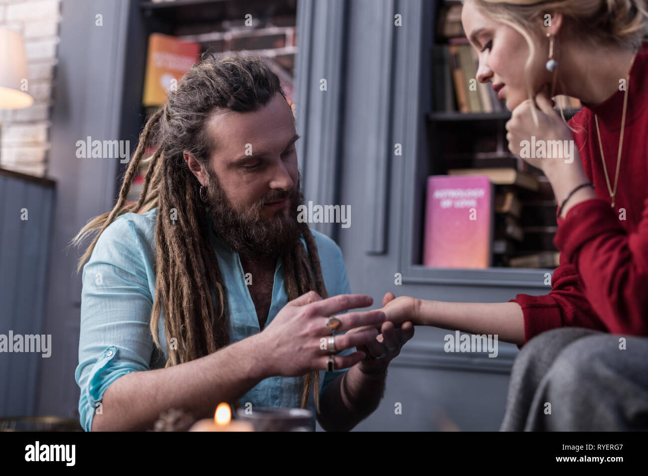 Homme barbu positif travailler comme chiromancer Banque D'Images