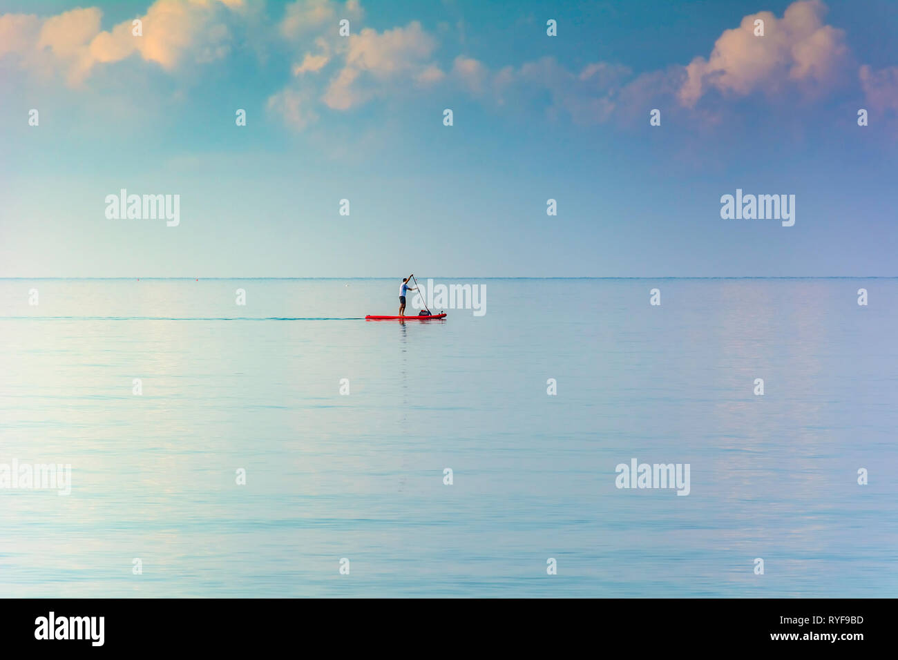 Man Stand up Paddling conseil en eaux libres - Horizontal de paddle voyager - Stand up Paddling embarquement sur l'eau calme mer océan Banque D'Images
