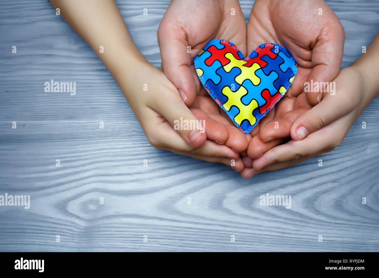 Journée mondiale de sensibilisation à l'autisme, ou de casse-tête puzzle dans coeur avec enfant autiste et du père mains Banque D'Images