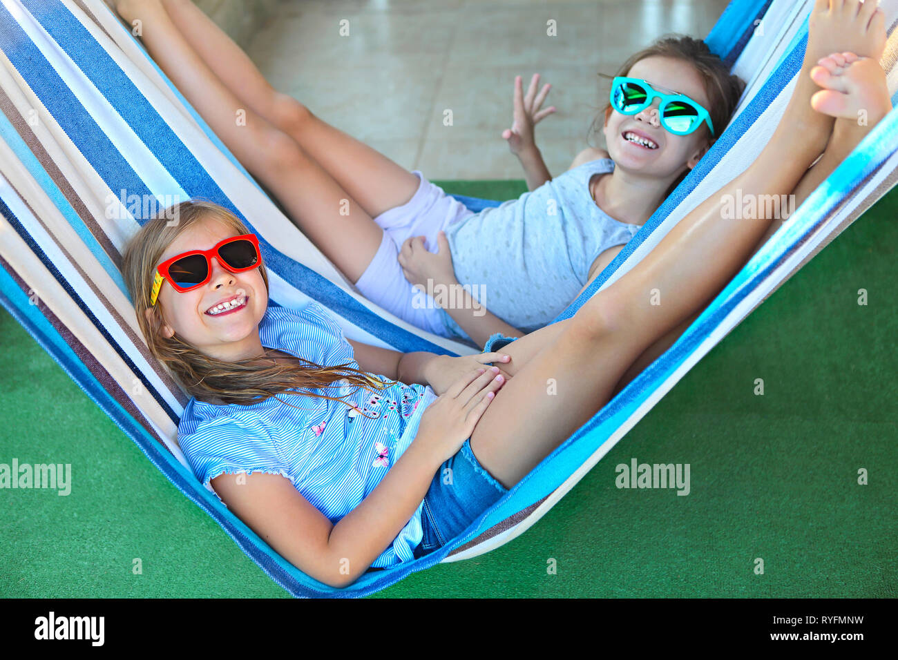 Deux petites filles heureux jouant sur hamac en journée d'été Banque D'Images
